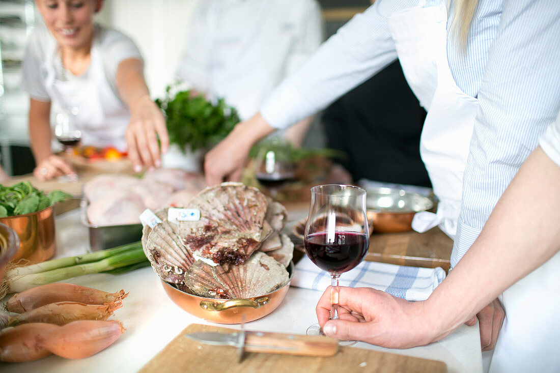 Junge Frauen mit Rotwein während eines Kochkurses