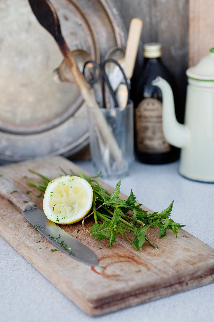 Lemon, mint and knife on chopping board
