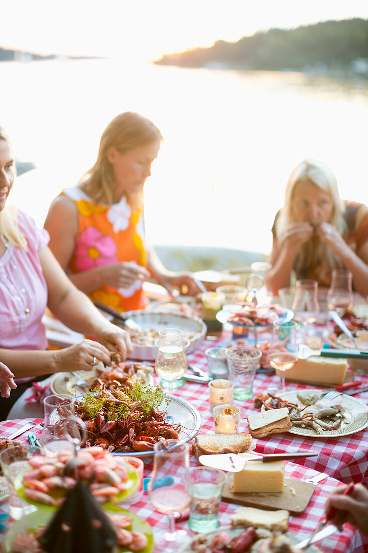 Frauen beim Flusskrebse essen