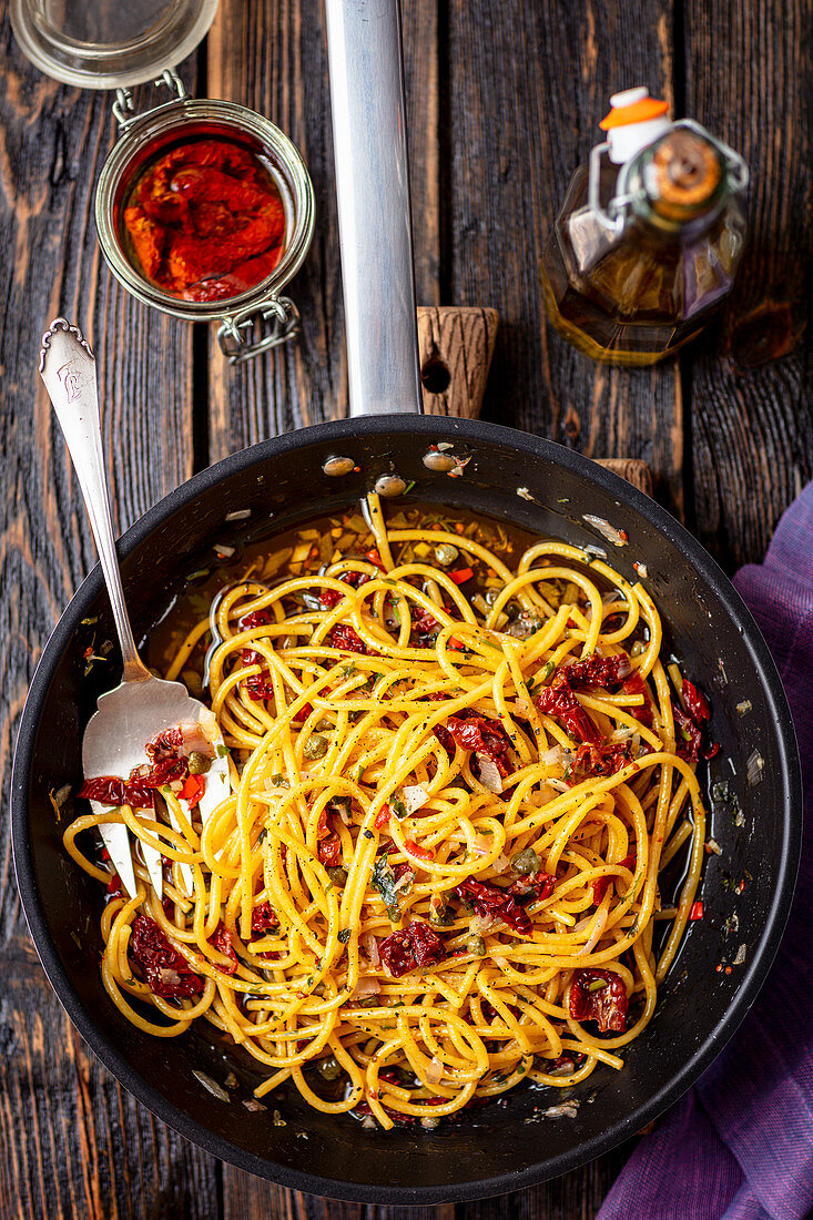 Spaghetti with dried tomatoes, capers, red onion and chili