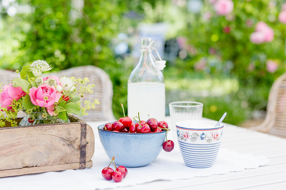 Kirschen und Zitronenlimonade auf Gartentisch