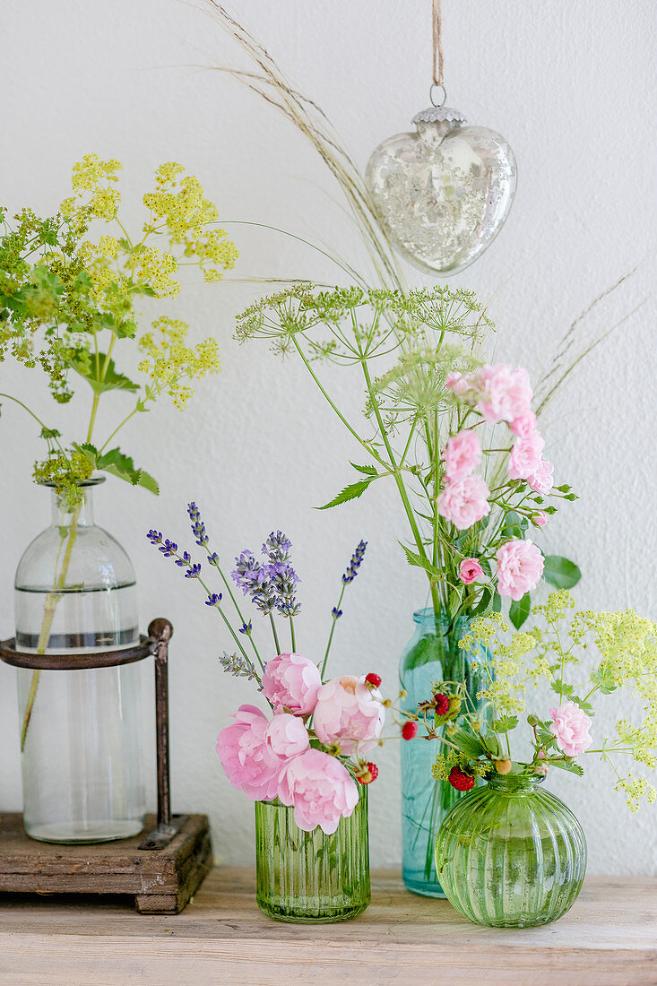 Rosen, Frauenmantel, Fenchel, Lavendel und Erdbeeren in Glasvasen