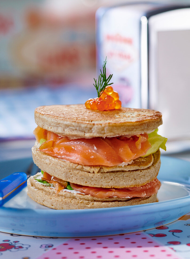 A stack of blinis with salmon and salmon caviar