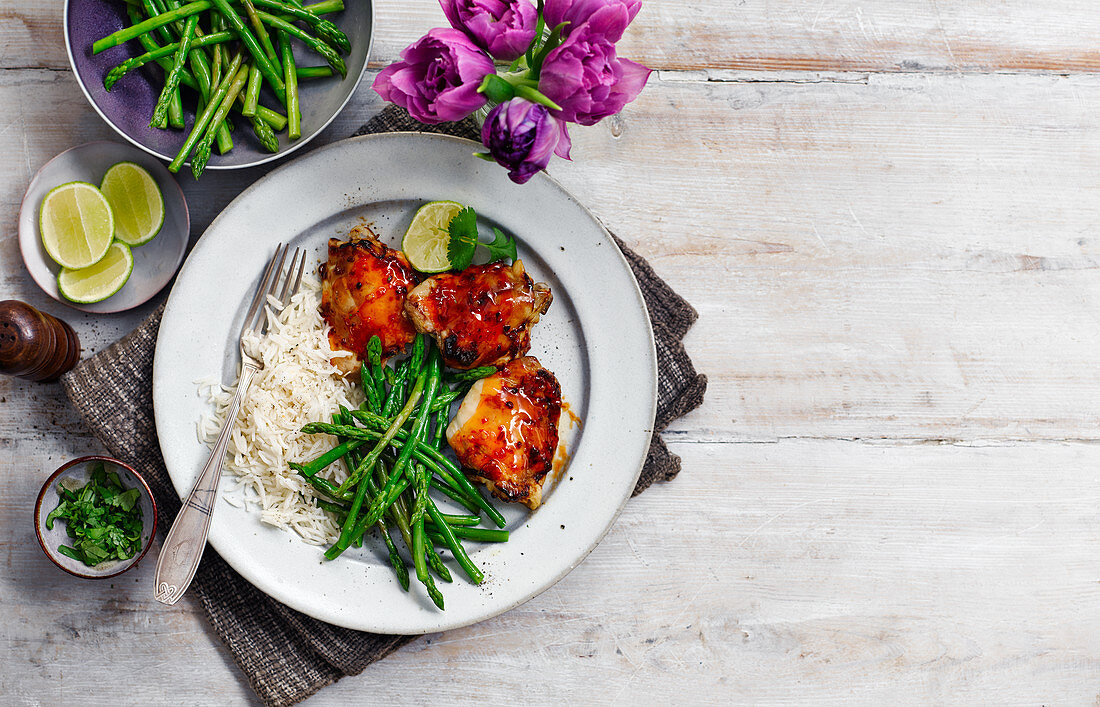Chicken in sweet and spicy sauce with rice and green asparagus