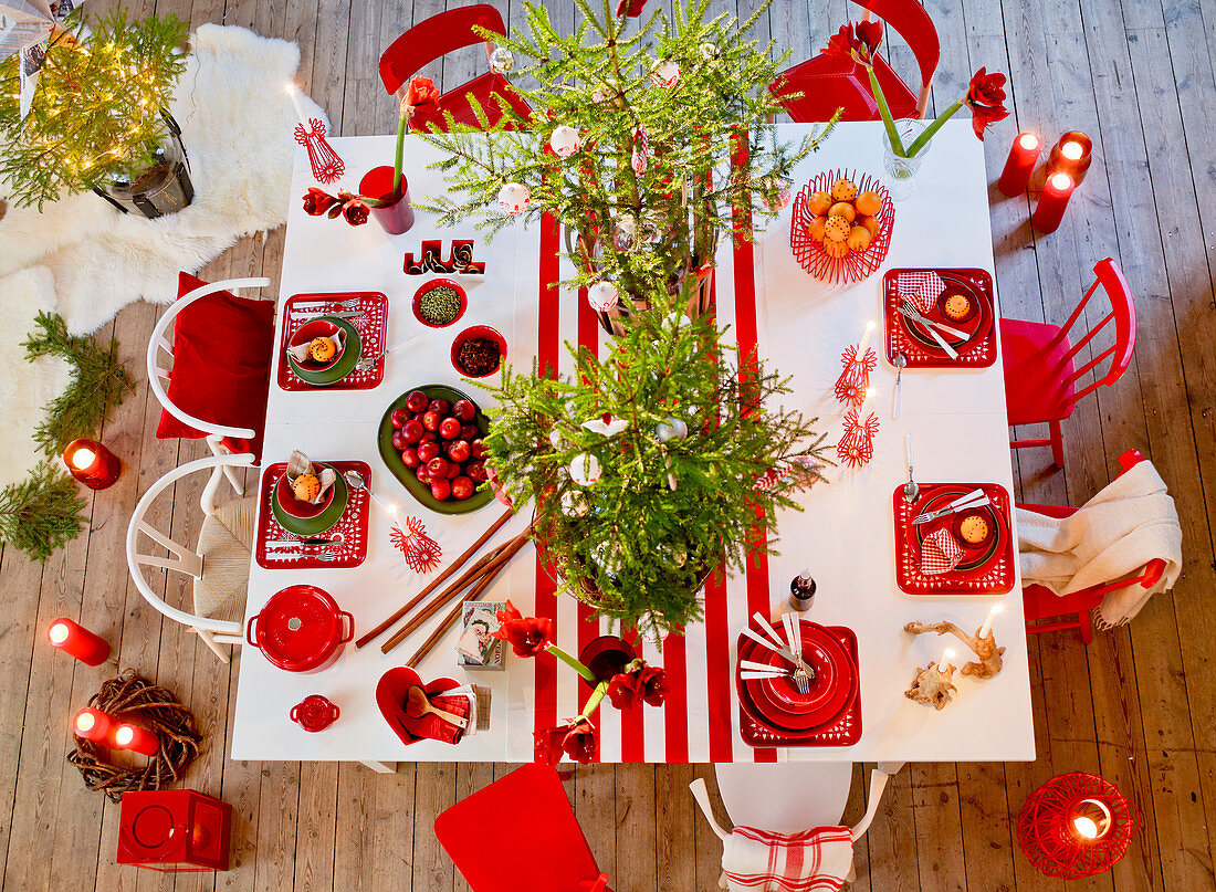 Gedeckter Weihnachtstisch in Rot-Weiß mit Christbäumchen