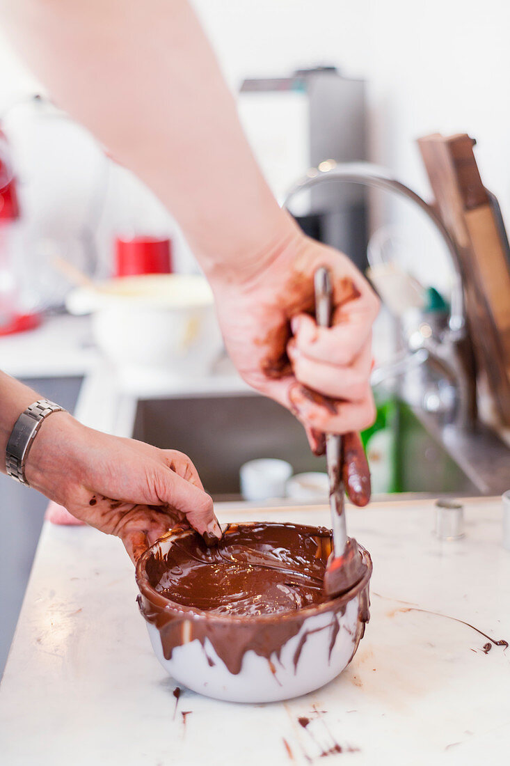 Person rührt geschmolzene Schokolade