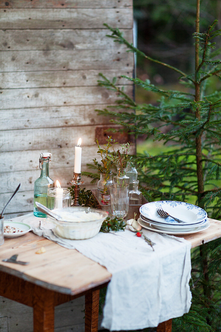 A rustic small table laid outside a wooden hut