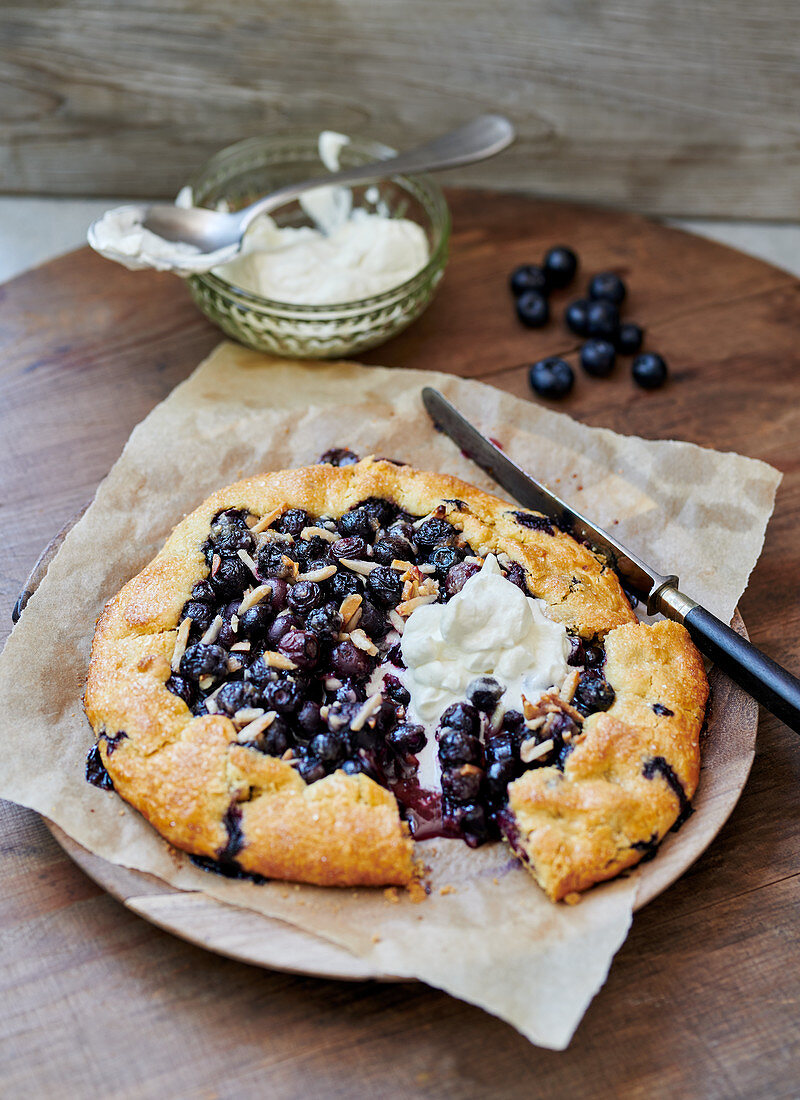 Blueberry tart with almonds and whipped cream