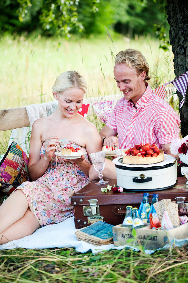 Paar isst Erdbeertarte beim Picknick