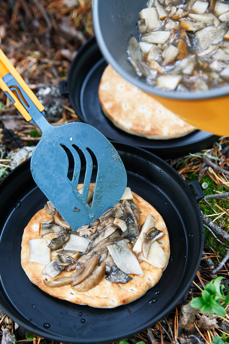 Flatbread with mushrooms cooked in a camping stove
