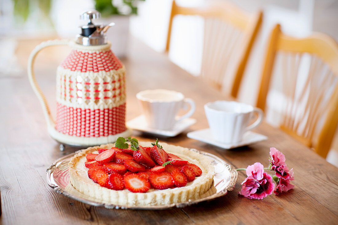 Strawberry tart and coffee on a wooden table