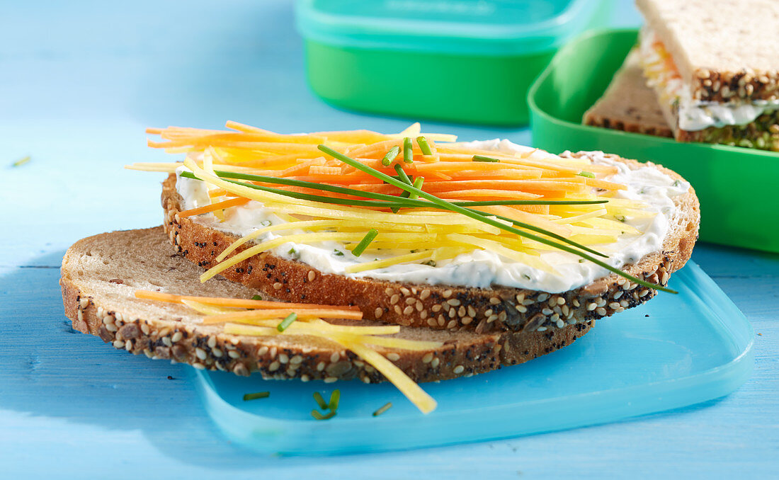Quark-Schnittlauch-Brot mit bunten Karotten vor Lunchbox