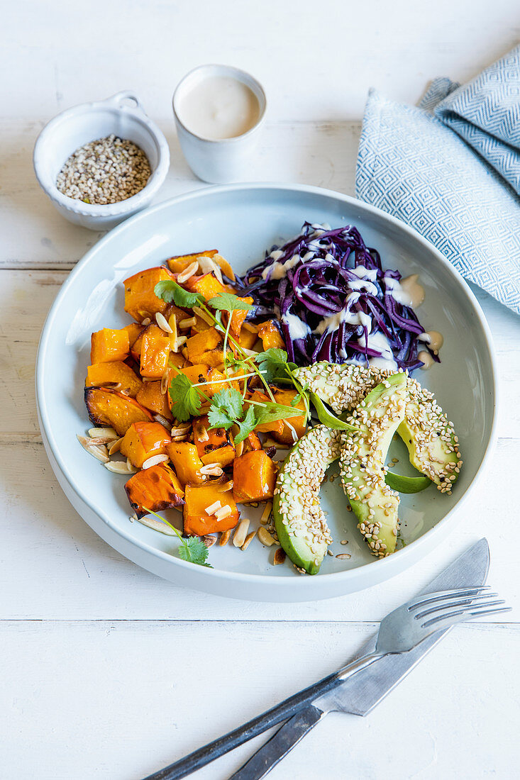 Red cabbage coleslaw with pumpkin and avocado coated with sesame seeds