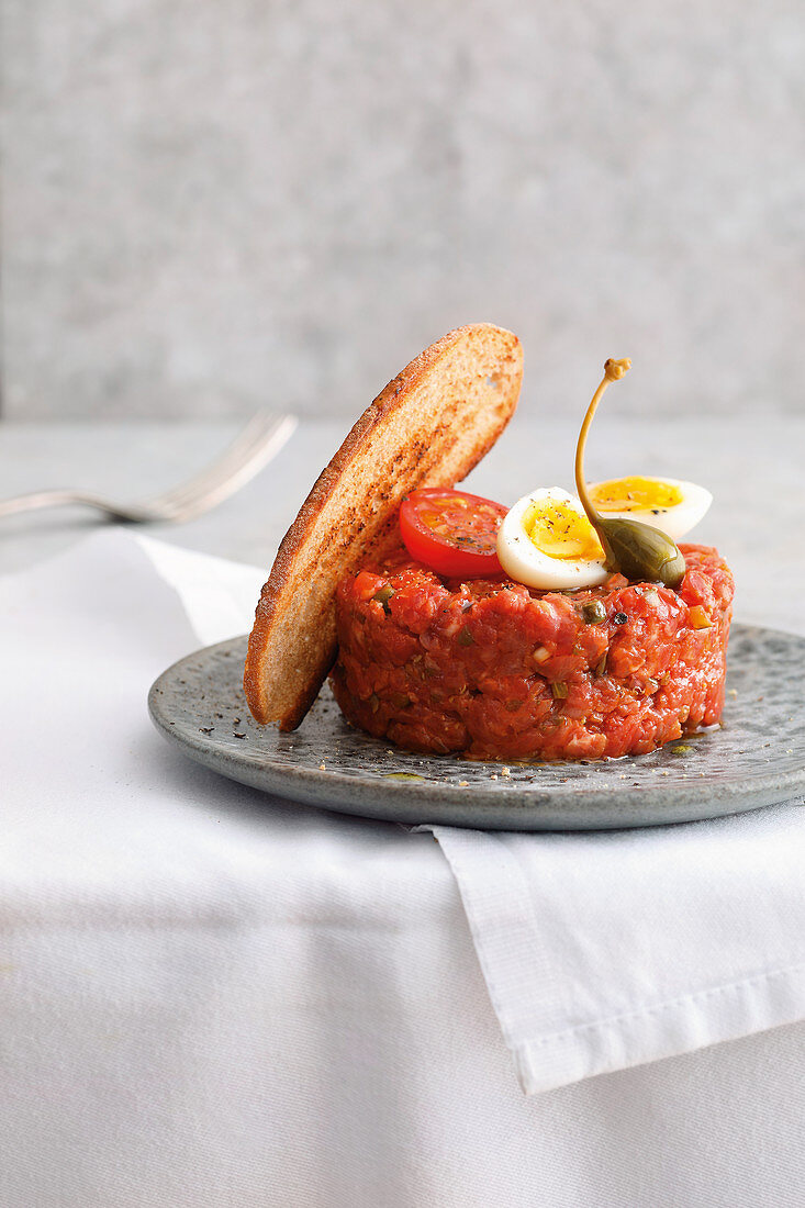 Beef tartare with quail's eggs and caper fruits