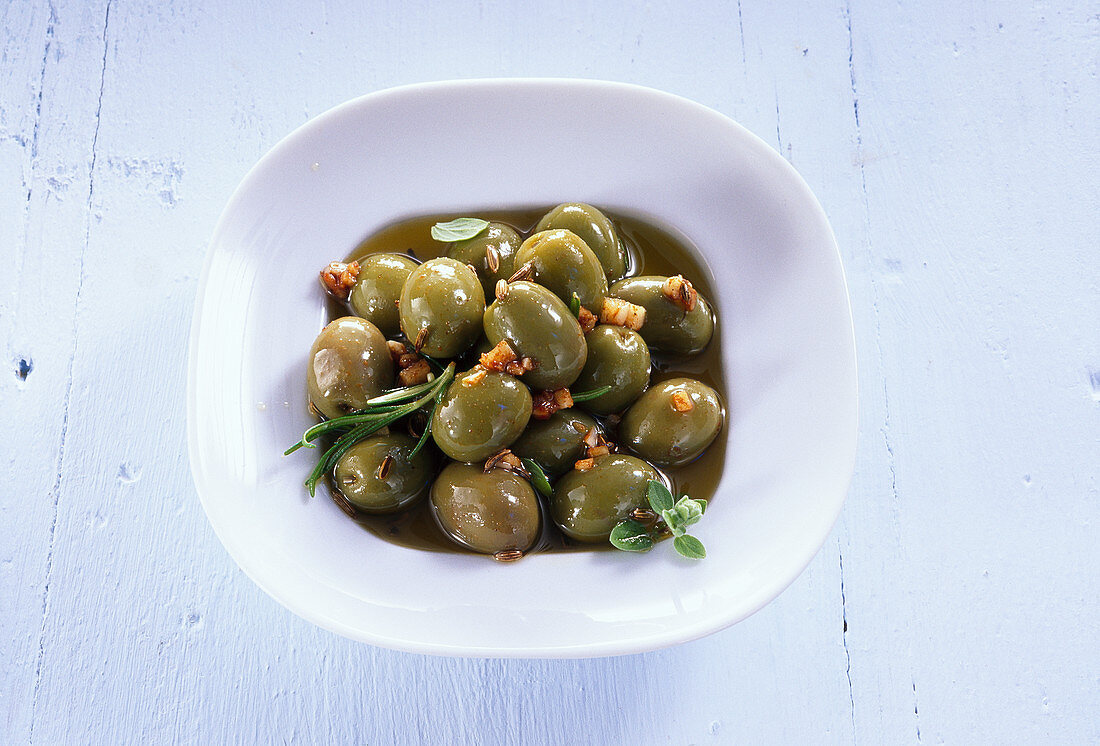 Eingelegte grüne Oliven mit Knoblauch und Kräutern