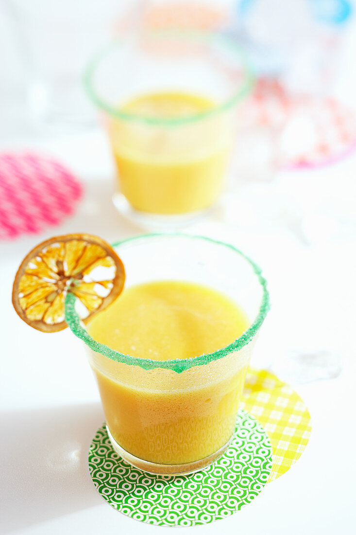 Papaya smoothie with banana decorated with a dried slice of orange
