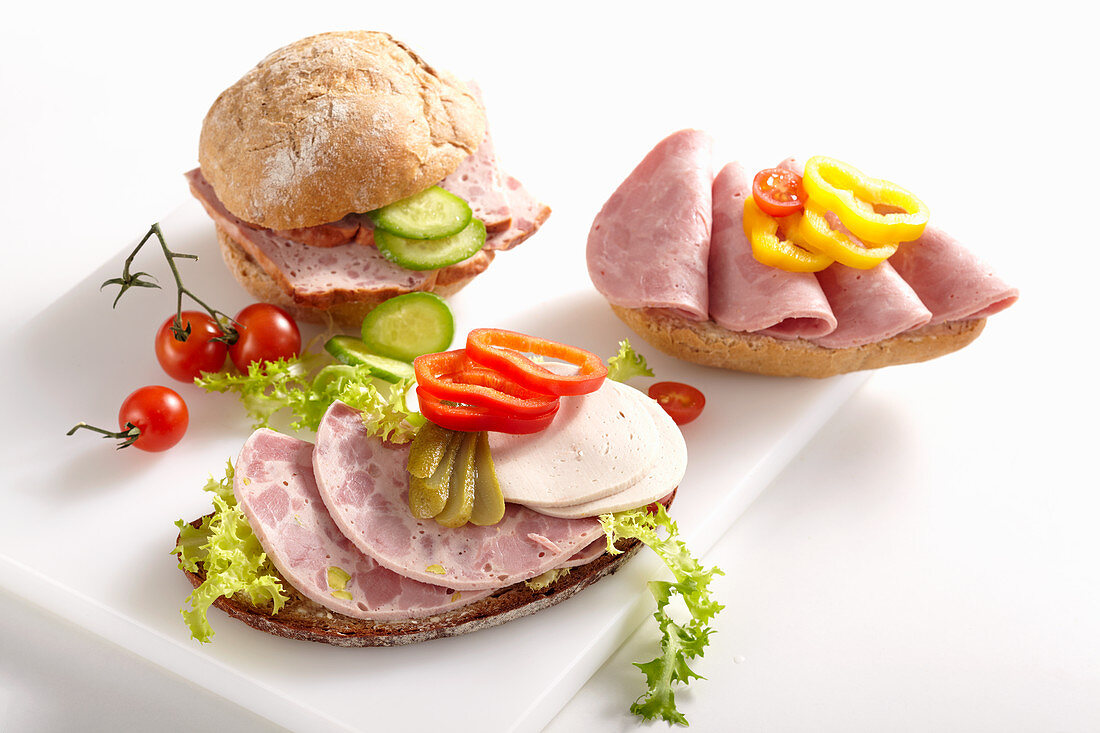 Sliced sausage on bread rolls with vegetables