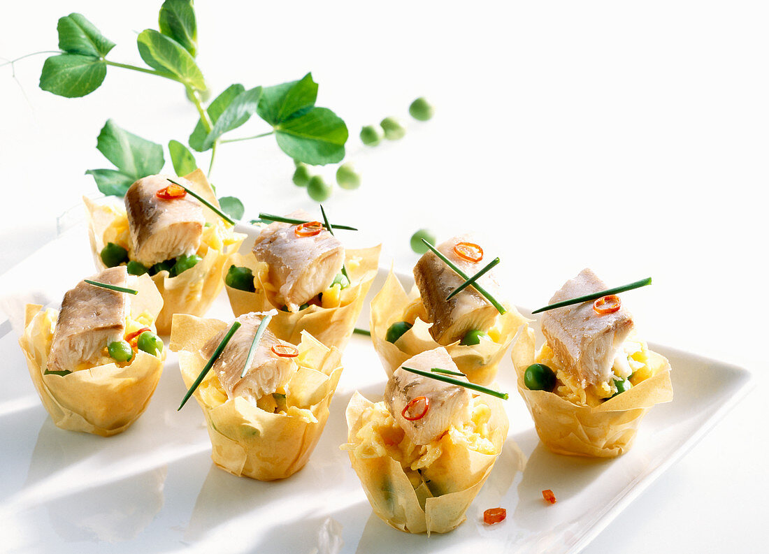 Filo pastry bowls with scrambled eggs, smoked eel, peas and chili