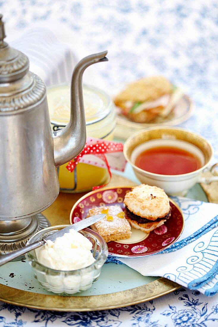 Sweet pastries, sandwiches and tea