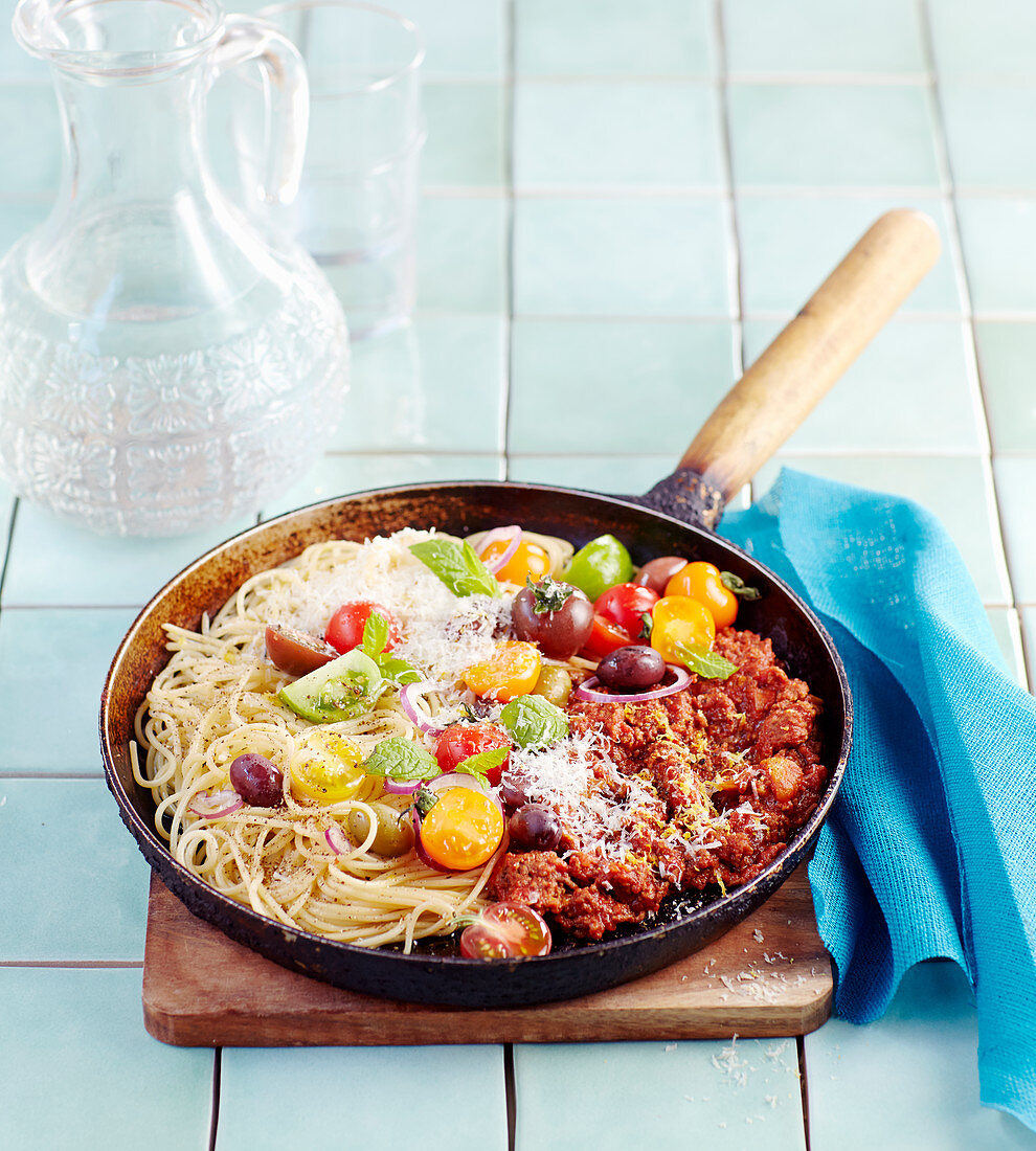 Spaghetti Bolognese mit Kirschtomaten und Basilikum in Pfanne
