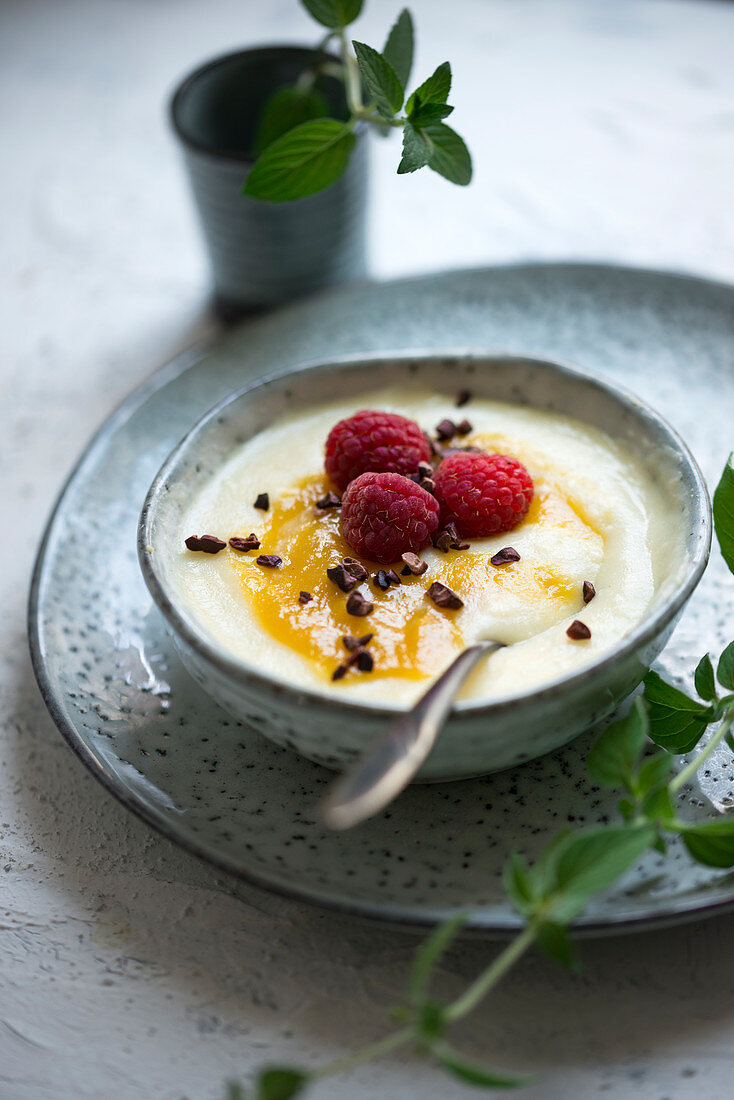 Veganer Hirsebrei (aus Hirseflocken) mit Mangopüree, Himbeeren und Kakaonibs