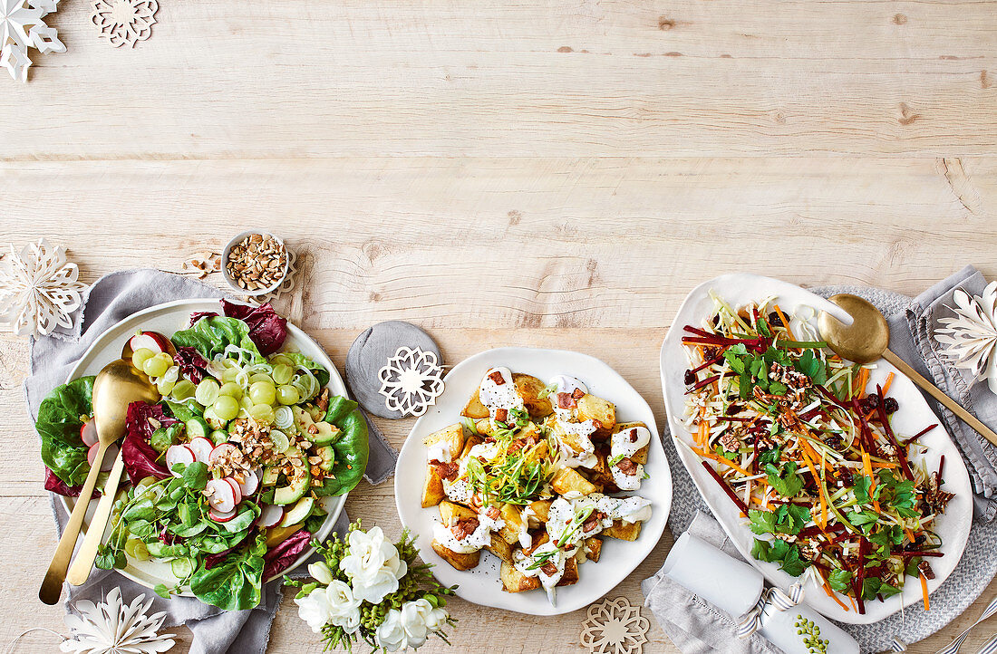 Green salad with pickled grapes, warm potato salad with cheesy sauce, festive slaw