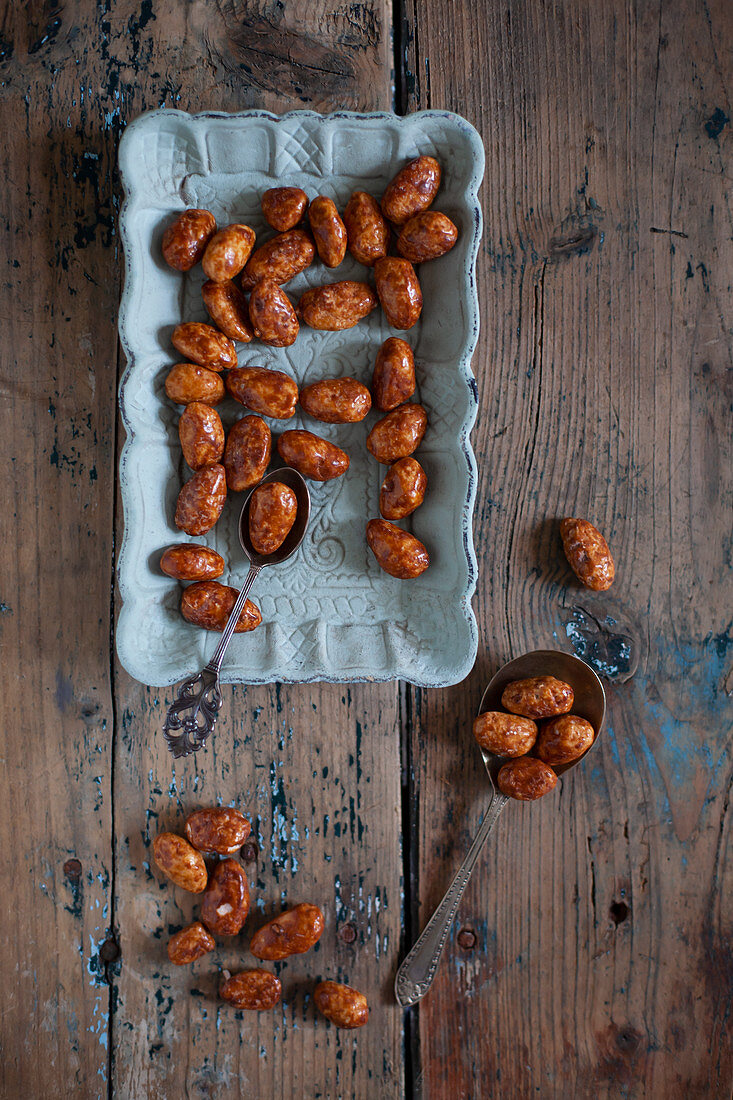 Caramelised nuts on blue plate and wooden table