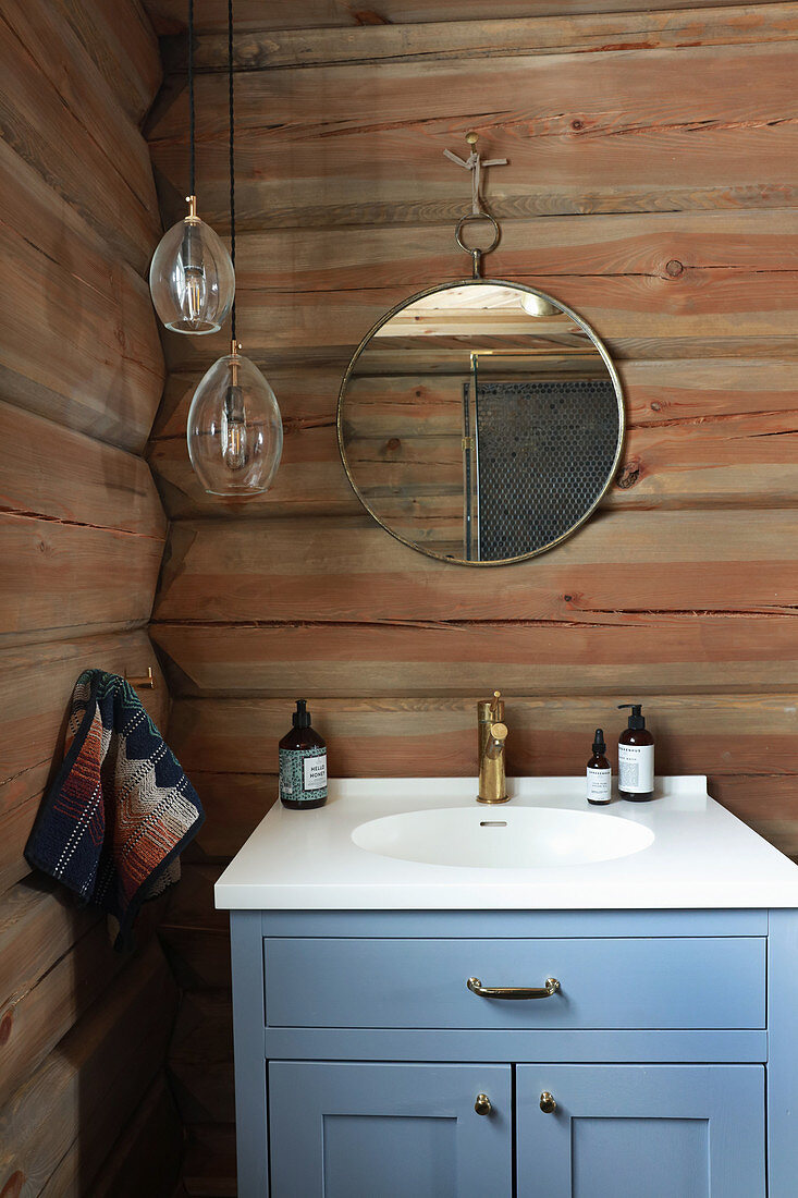 Blue sink unit in bathroom of log cabin