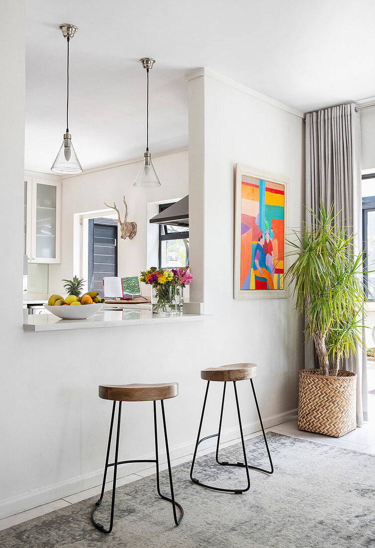 Two barstools below pass-through into kitchen