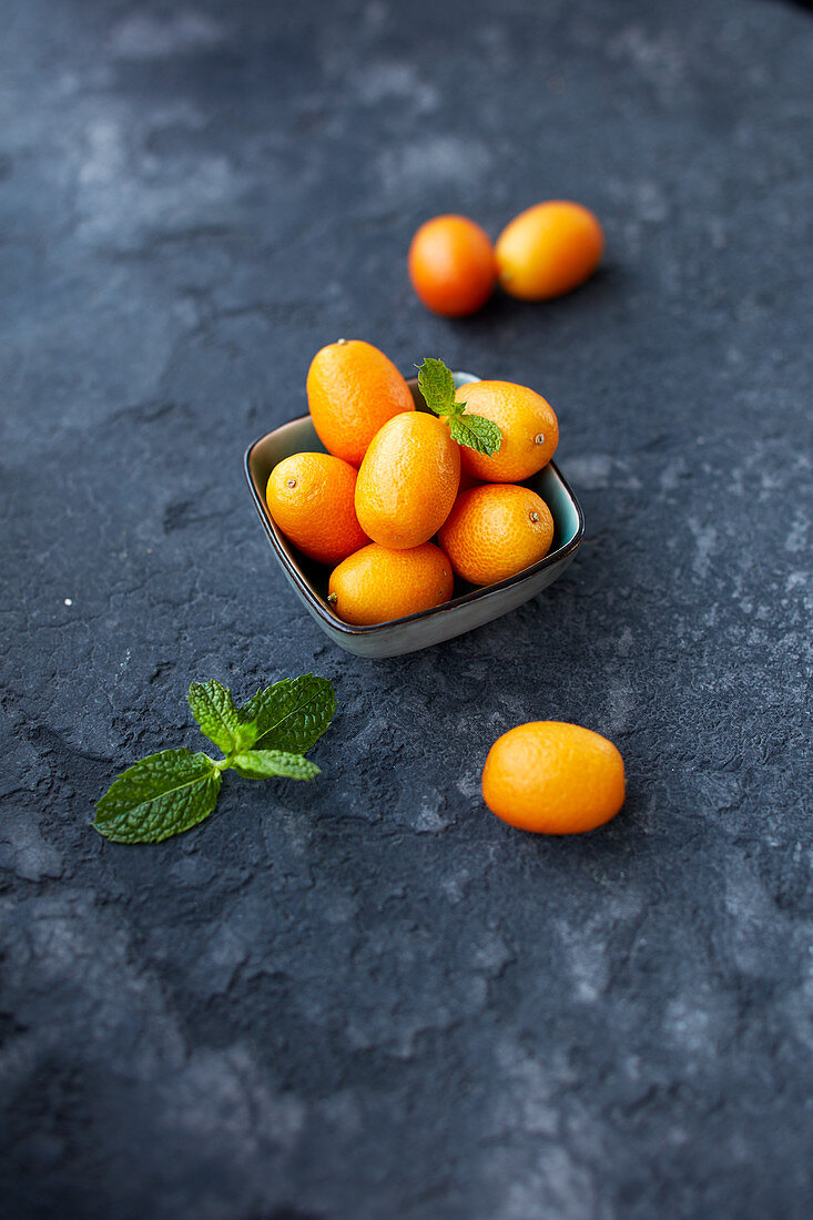 Kumquats in a small bowl with mint