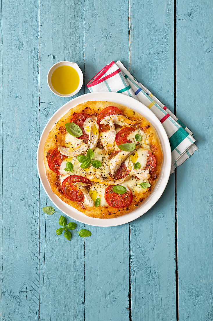 Fladenbrot-Pizza mit Hähnchenfleisch, Tomaten und Basilikum