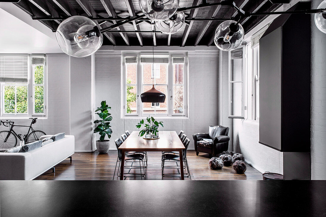 View into the open living room with dining table and sofa in the loft