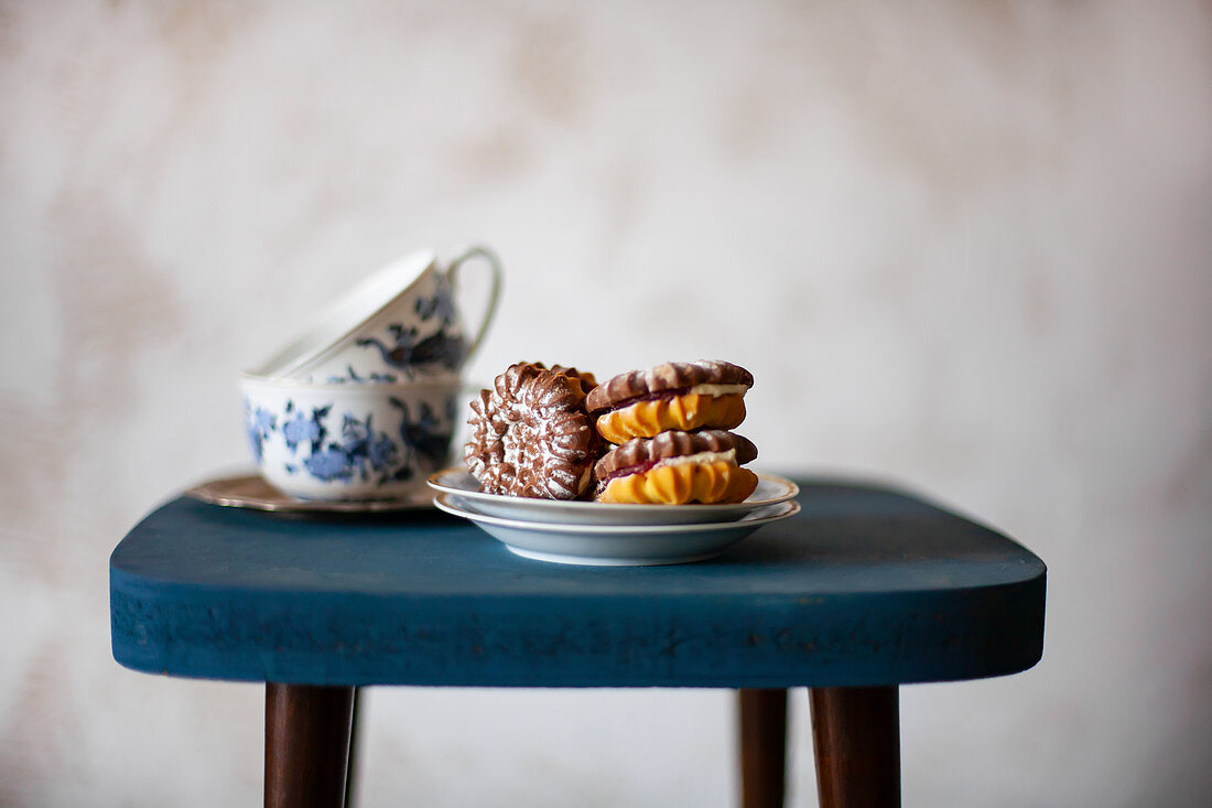 Stuffed chocolate-vanilla biscuits and teacups