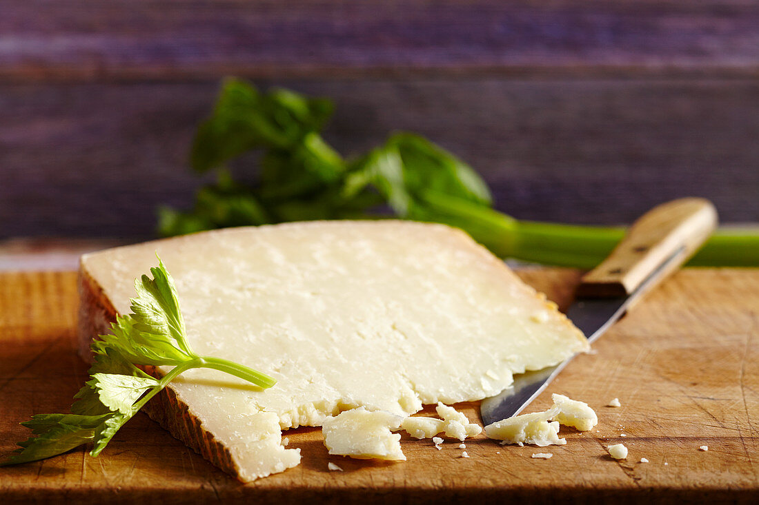 Pecorino sardo, hard cheese made from sheep's milk (Sardinia) on a wooden board with a knife