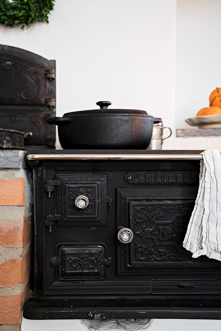 Antique, cast iron, wood-burning stove in country-house kitchen