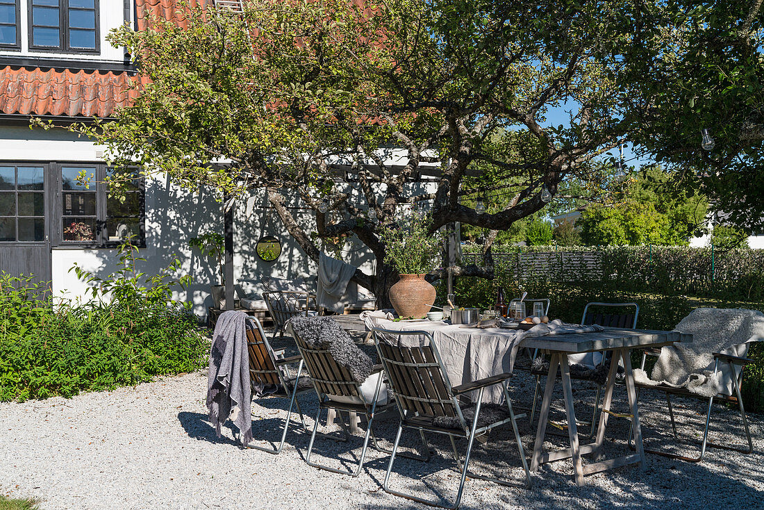 Set garden table on gravel terrace in summer garden