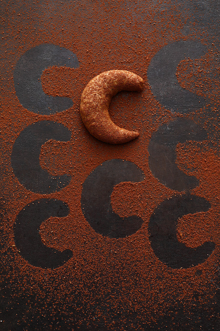 A mocha and nut crescent biscuit with cocoa powde