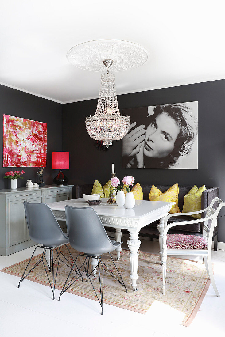 Chandelier and dark grey walls in eclectic dining area