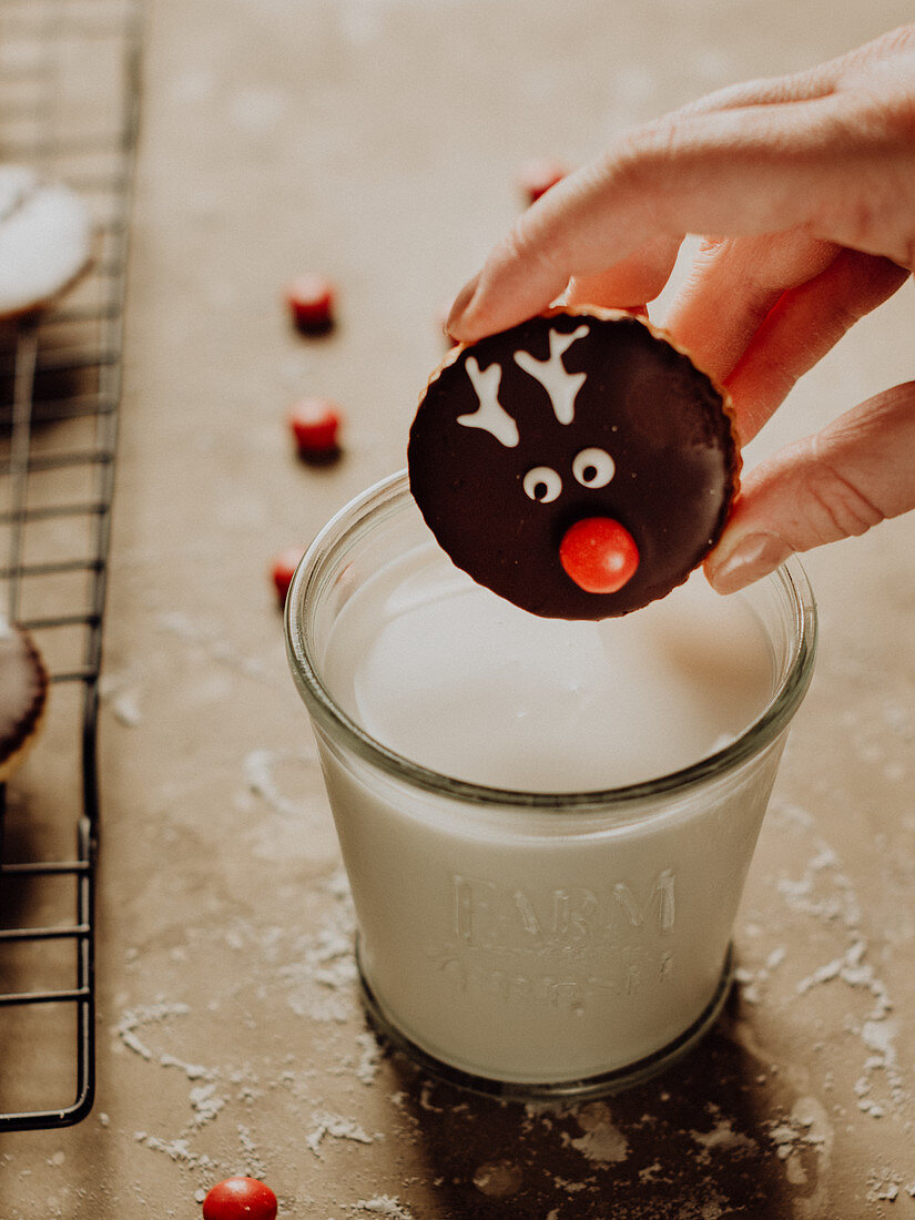 Rentier-Weihnachtsplätzchen in Glas Milch eintauchen