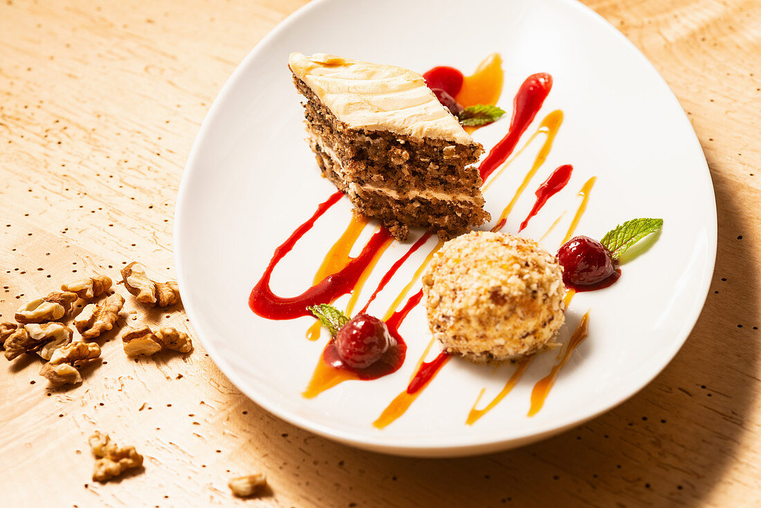 Walnuss-Krokanteisknödel mit Vanilleeis und Apfel-Walnuss-Karamell-Törtchen auf marinierten Himbeeren