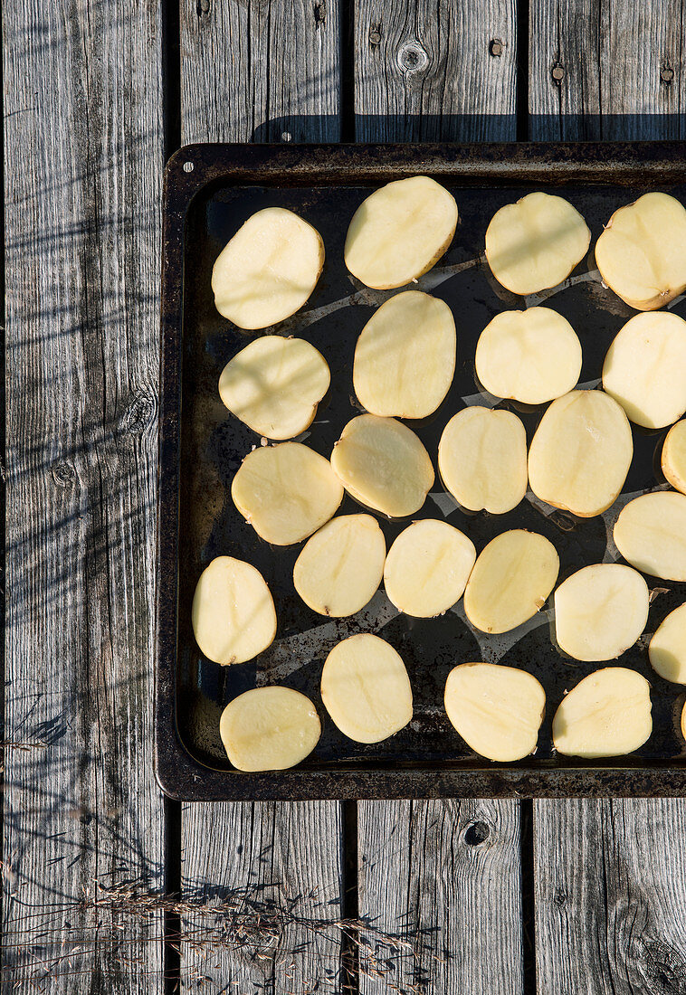 Sliced potatoes on baking tray