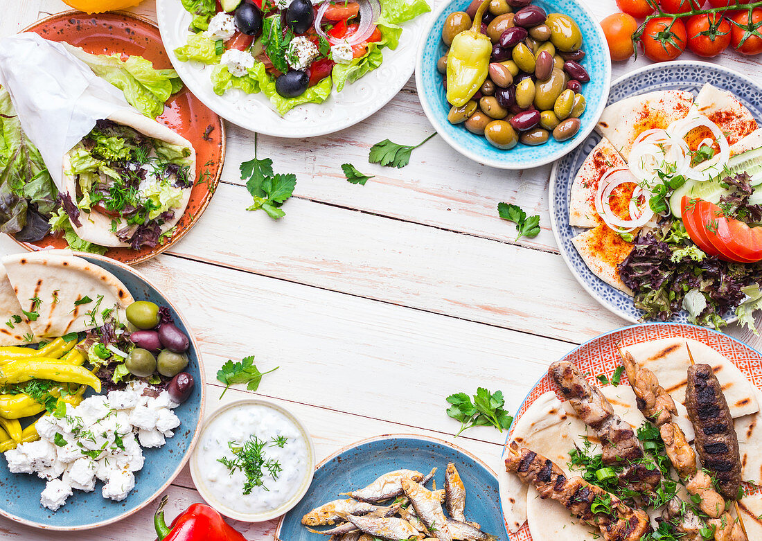 Greek food: Meze, gyros, souvlaki, fried fish, pita, greek salad, tzatziki, assortment of feta, olives and vegetables