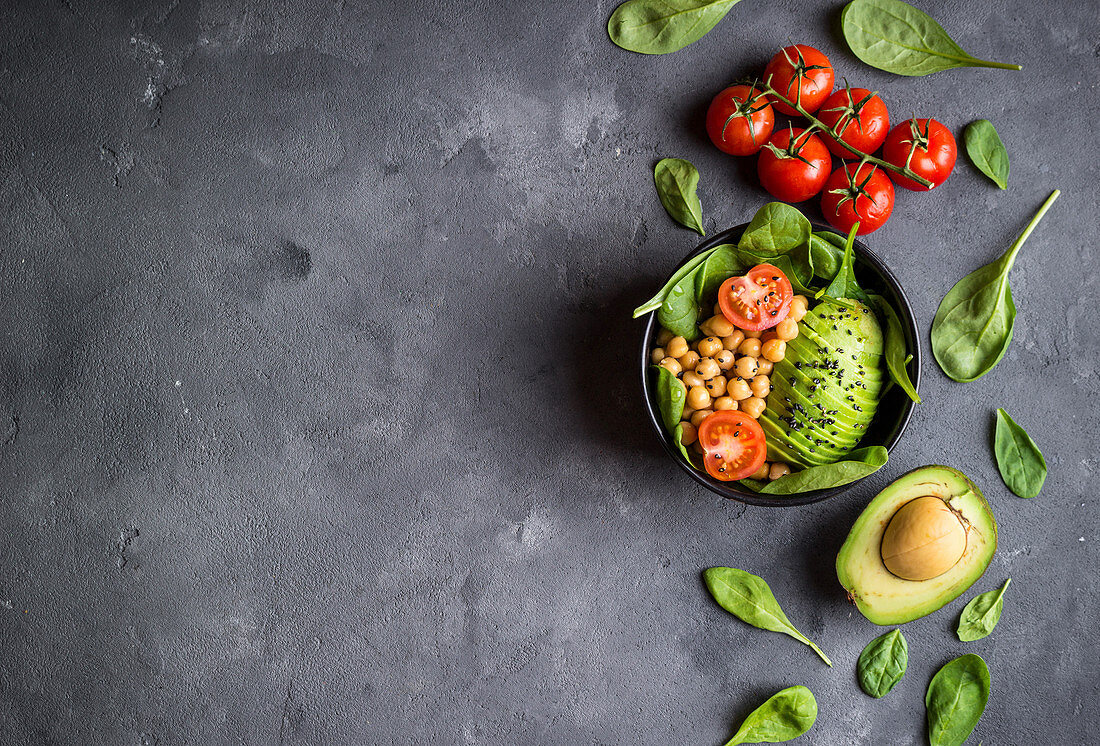 Healthy vegetarian salad with avocado, chickpeas, spinach, sesame in bowl
