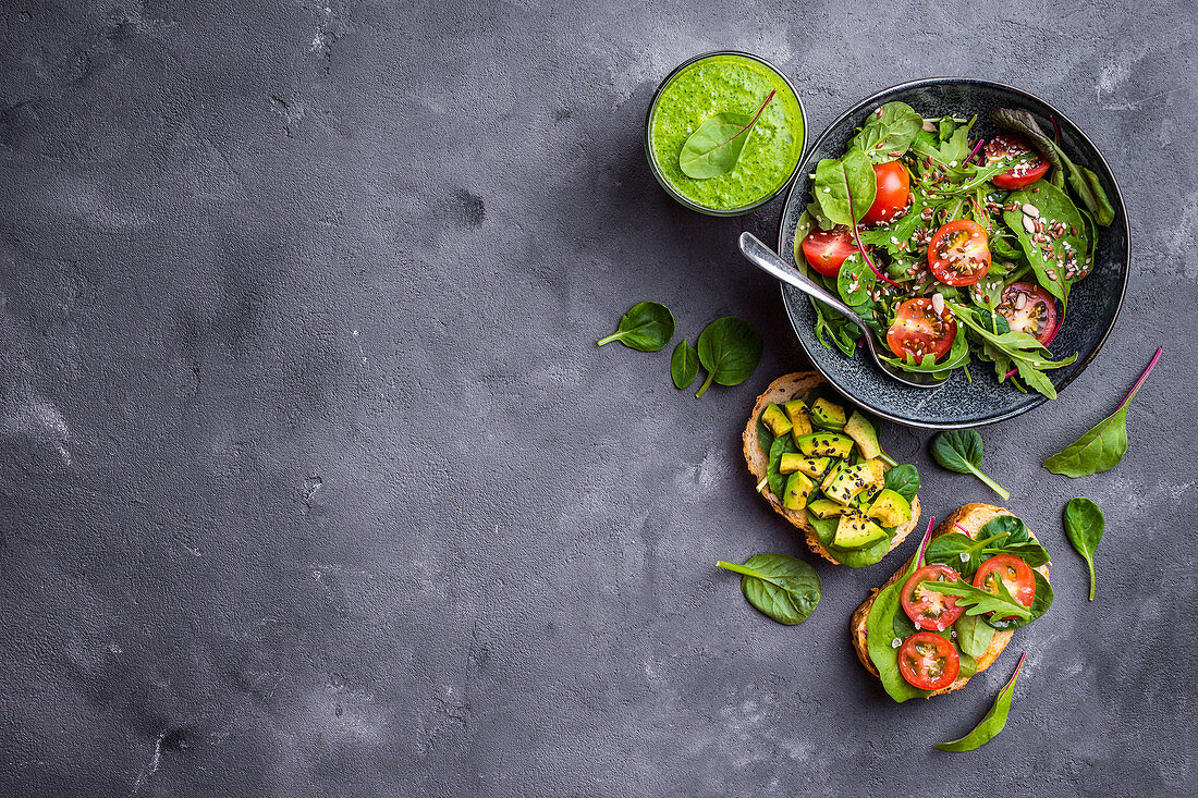 Gemüsesalat, belegte Brote und grüner Smoothie