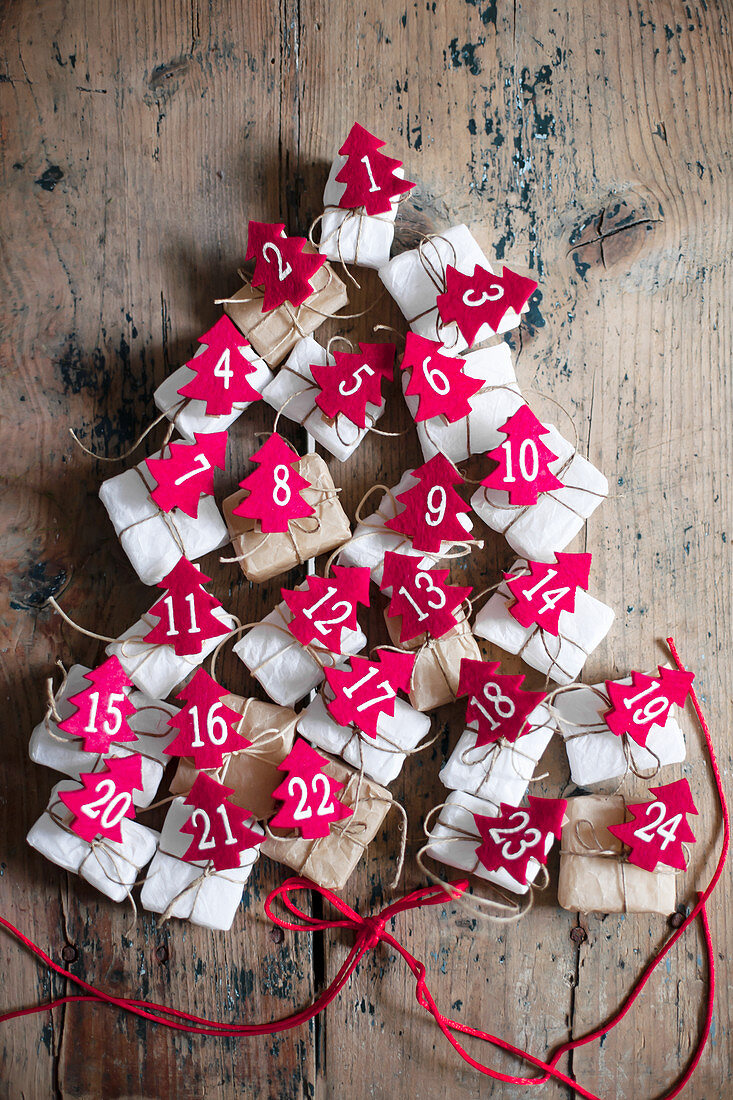 Gifts with numbered, red felt Christmas trees arranged in tree shape