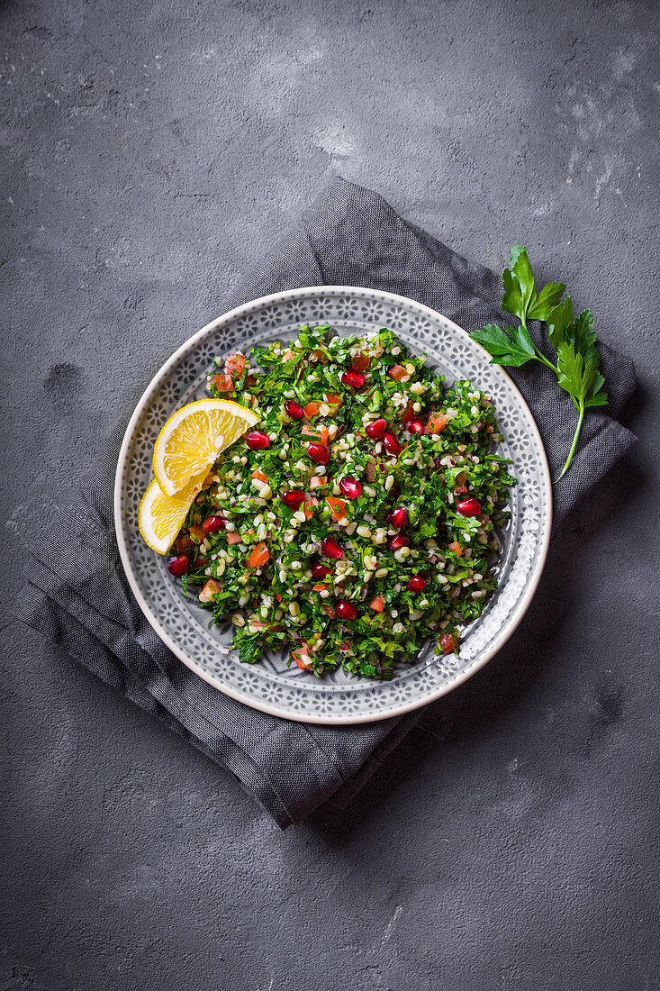 Tabbouleh salad on plate, rustic concrete background