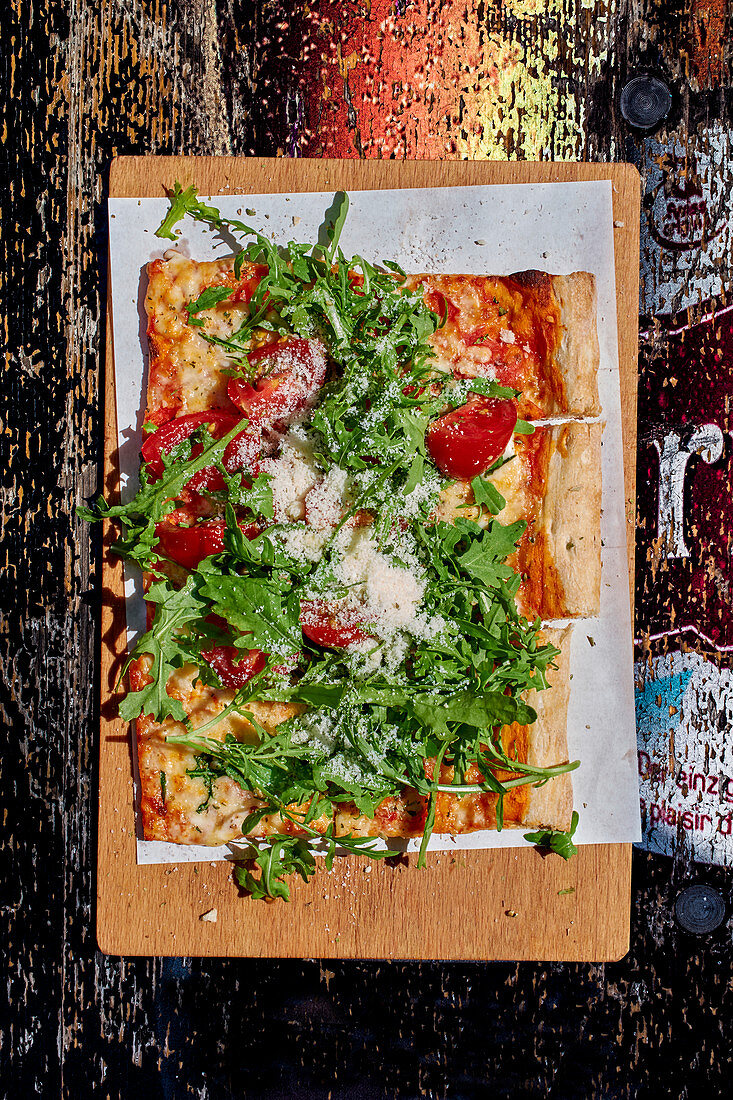 Pizza mit Rucola, Tomaten und Parmesan