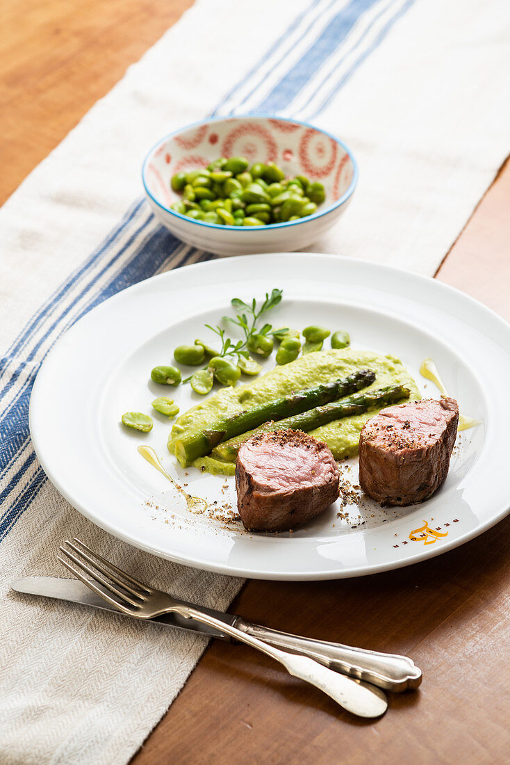 Niegrig gegartes Schweinefilet mit Saubohnenpüree und geschmorter Jungzwiebel