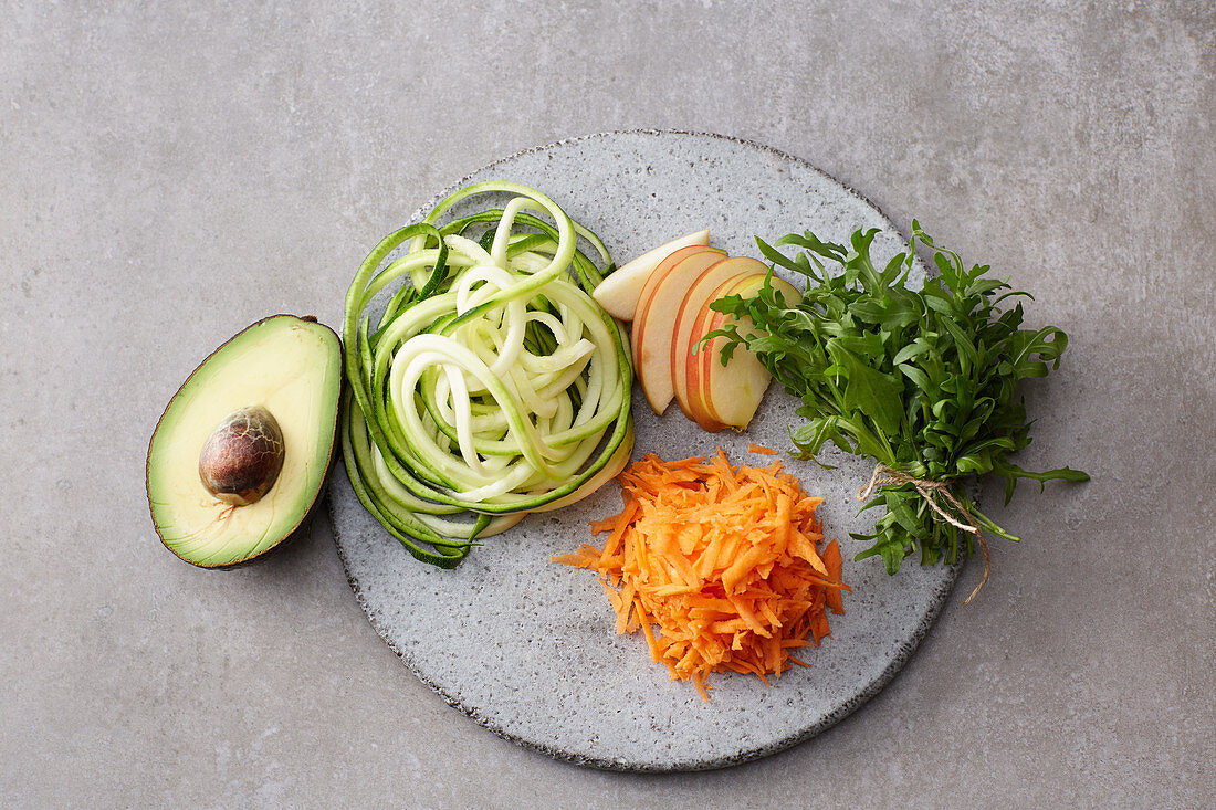 Geschnittenes und geraspeltes Gemüse und Obst für Bowls