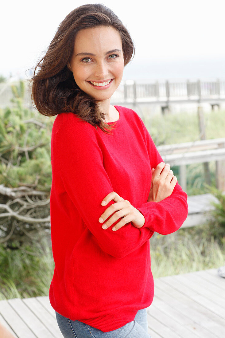 A young brunette woman wearing a red jumper